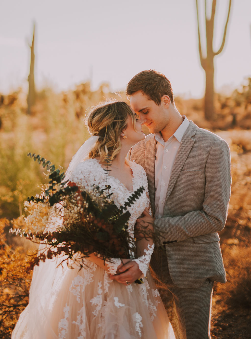 Arizona Elopement in front of cacti the bride and groom are looking at each other