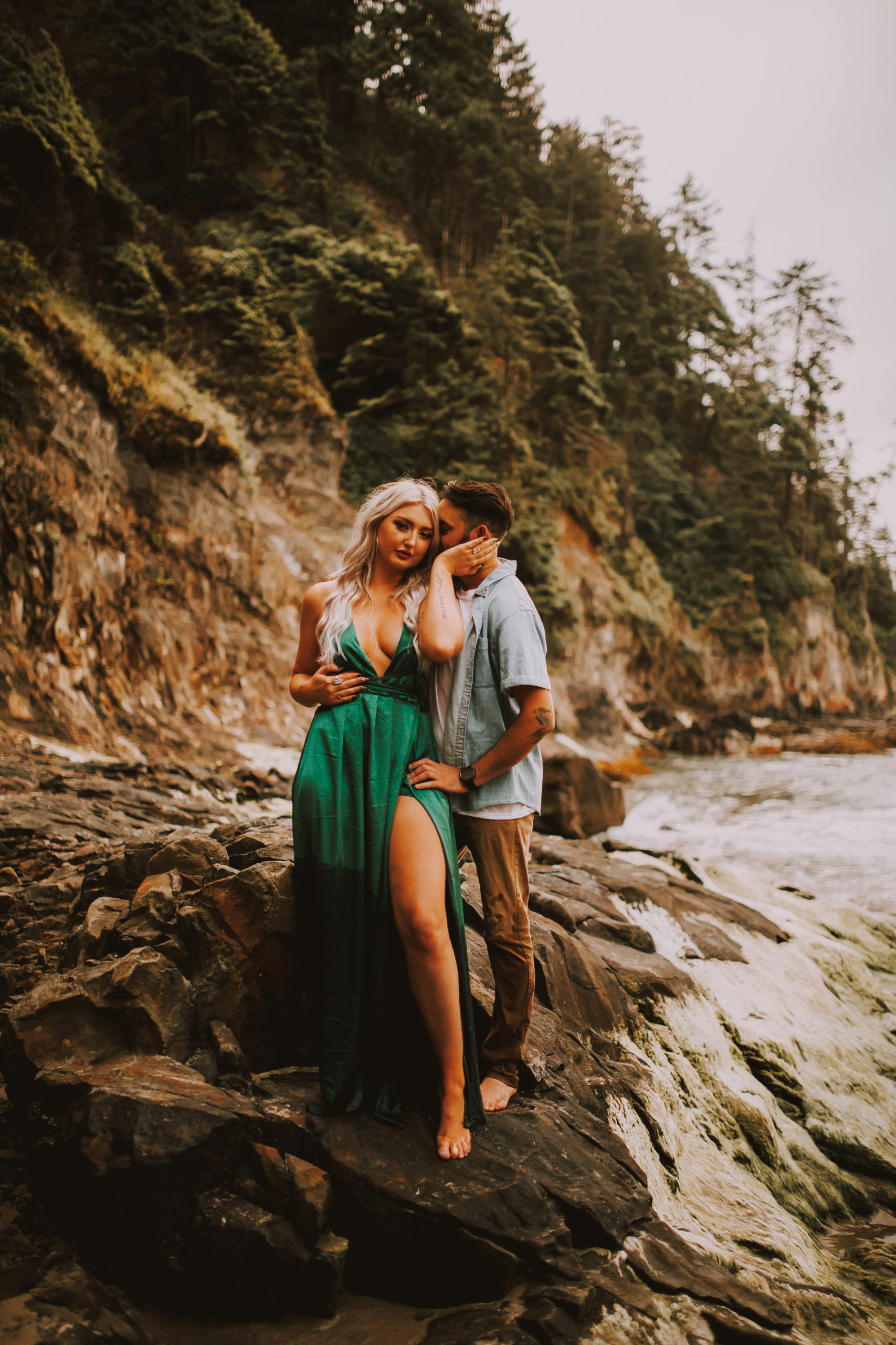 Intimate bride in a green dress on the coast of Oregon leaning onto her future husband